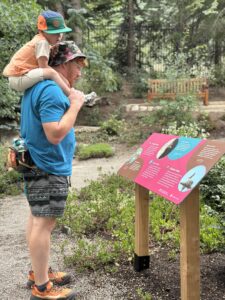Family looking at Habitats exhibit sign